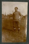 Photograph of unidentified Miami Military Institute cadet in football garb, standing in a field, 1904