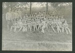Photograph of a group of Miami Military Institute cadets and faculty seated on a hill in a wooded area, 1903