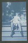 Photograph depicting a boy in Miami Military Institute uniform, seated on a step and holding a baby, 1904