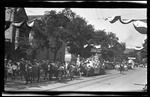The parade Queen, Helen B. Fishter, holding the first airplane while riding in the parade during the 1909 Wright Brothers Homecoming Celebration