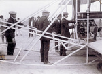 Orville Wright and others stand near the Flyer