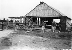 Charlie Taylor and soldiers in front of a hangar by U.S. Air Service