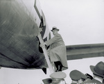 Orville Wright climbing ladder to Lockheed Constellation airplane