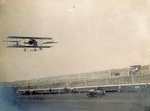 Curtiss biplane in flight at Indianapolis Motor Speedway