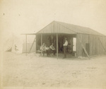 Enjoying the shade of the camp building at Kill Devil Hills by George Spratt
