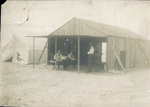 Enjoying the shade of the camp building at Kill Devil Hills by George Spratt