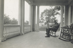 Bishop Milton Wright sitting in rocking chair on porch