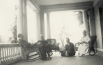 Orville and Katharine Wright sitting on the porch with friends