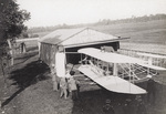Wilbur Wright assembling canvas on flyer