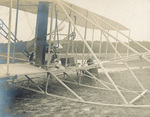 Charlie Taylor making adjustments to Wright Model A Flyer by C. H. Claudy