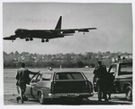 Two Men Watch as Boeing B-52 Stratofortress Flies Over Runway at Wright Field. by Dayton Daily News and Wally Nelson