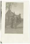 Two men standing in front of a cottage