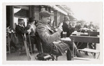 Soldier seated and looking at drink